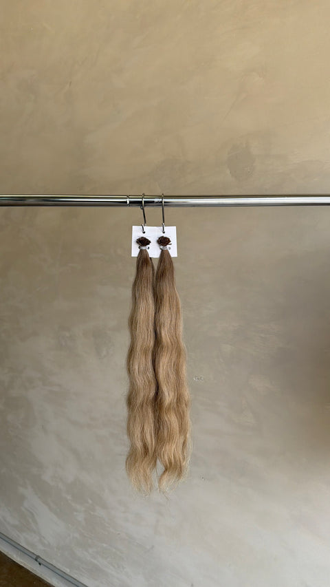 Long blonde Slavic keratin bond extensions with a beautiful flowing wave, adding natural-looking length, volume and texture in North Lakes, North Brisbane
